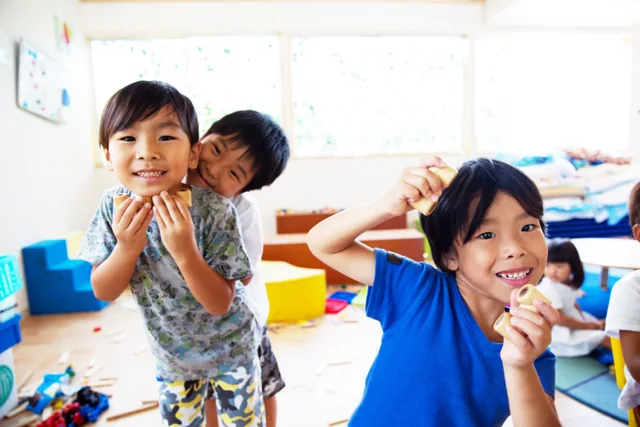 Children smiling and exploring wooden toys together